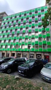 un grande edificio con macchine parcheggiate di fronte di Hotel Miramonti a Torino