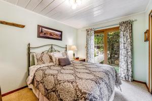 een slaapkamer met een bed en een glazen schuifdeur bij Mendocino Dunes - Distant Shores in Fort Bragg