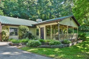 una pequeña casa verde con porche en South Asheville home with hot tub just 11 miles to downtown, en Asheville