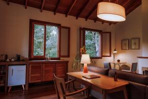 a kitchen and living room with a table and a couch at Fazenda Santa Vitória in Queluz