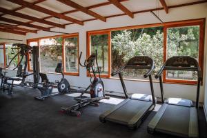 un gimnasio con varias máquinas de correr en una habitación con ventanas en Fazenda Santa Vitória, en Queluz