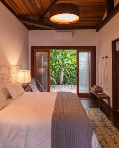 a bedroom with a bed and a large window at Fazenda Santa Vitória in Queluz