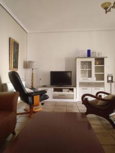 een woonkamer met 2 stoelen en een flatscreen-tv bij Casa Rural POSADA DEL JUCAR in La Gila