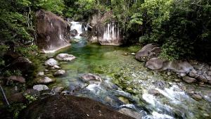 una corriente de agua con rocas y una cascada en Fazenda Santa Vitória, en Queluz