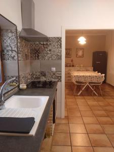 a kitchen with a sink and a kitchen with a table at Casa Rural POSADA DEL JUCAR in La Gila +32 photos