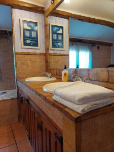 y baño con 2 lavabos, bañera y espejo. en Casa Rural POSADA DEL JUCAR, en La Gila