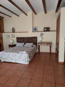 1 dormitorio con 1 cama y 2 mesas. en Casa Rural POSADA DEL JUCAR en La Gila