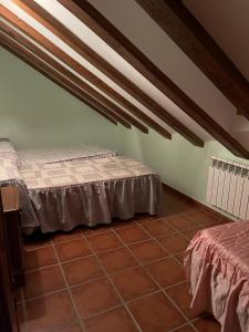 a bedroom with two beds and a tile floor at Albergue Rural Gorillo in Gor