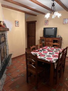a dining room with a table and a tv at Albergue Rural Gorillo in Gor