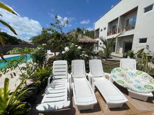 a group of lounge chairs and a table on a patio at Chalé Murici Lençóis in Santo Amaro