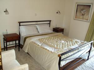 1 dormitorio con 1 cama grande y 1 silla en Guest House Pantos Kairou, en Karkaloú