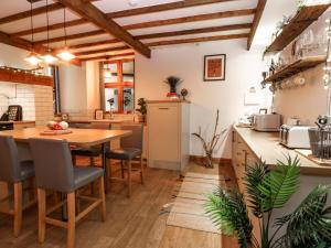Una gran cocina con una mesa y sillas de madera. en Baywatch St David's View, en Lynton