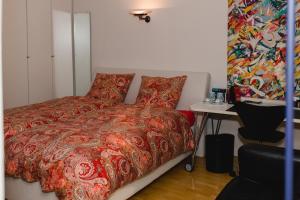 a bedroom with a bed with a red comforter at Modernes und gemütliches Designerzimmer in Langensteinbach