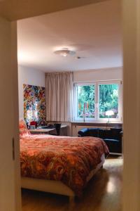 1 dormitorio con 1 cama, escritorio y 2 ventanas en Modernes und gemütliches Designerzimmer en Langensteinbach
