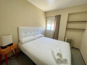 sypialnia z białym łóżkiem i 2 ręcznikami w obiekcie Seafront old Town w mieście Benidorm