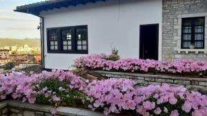 um ramo de flores cor-de-rosa em frente a uma casa em Hotel Vila Aleksander em Berat