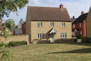 an old brick house with a stone fence at The Silverstone House. Comfort, Convenience and no hassle at the doorstep of Silverstone Race Circuit. in Silverstone