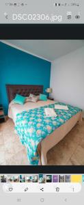 uma fotografia de um quarto com uma cama com uma parede azul em Apartamento Lo de Ana em Termas de Río Hondo