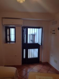 um quarto com uma porta e duas janelas em La Casita de Zahara de la Sierra em Zahara de la Sierra