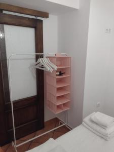 1 dormitorio con cama y armario rosa en La Casita de Zahara de la Sierra, en Zahara de la Sierra