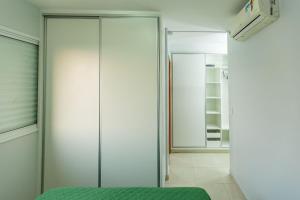 um quarto com um armário e uma porta de vidro em Apt moderno 3 suítes churrasqueira Goiânia em Goiânia