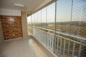 Cette chambre dispose d'un grand balcon avec une grande fenêtre. dans l'établissement Apt moderno 3 suítes churrasqueira Goiânia, à Goiânia