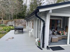 een overdekt terras met een tafel en stoelen op een huis bij Holiday home VäTö IV in Harg