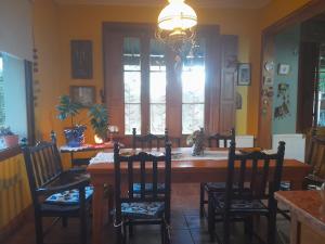 a dining room with a table with chairs and a chandelier at Casona Leyría Boutique in Azul