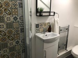 a bathroom with a sink and a shower and a toilet at Snowdon House, 8 bedrooms, sleep 16, close to Blackrock Sand in Porthmadog +40 photos