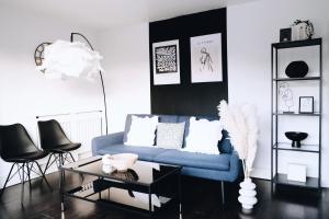 Bee Stays - Northway House في وارينغتون: غرفة معيشة مع أريكة زرقاء وطاولة