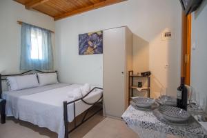 a small bedroom with a bed and two tables at Takis Apartments Tzoumerka 