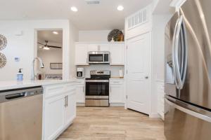 a kitchen with white cabinets and a refrigerator at Bear Lake Beautiful Brand New End Unit in Garden City