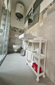 a bathroom with a sink and a red suitcase at Alla Mezzora - Finalborgo in Finale Ligure