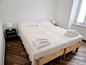 a bedroom with a large bed with towels on it at Alla Mezzora - Finalborgo in Finale Ligure