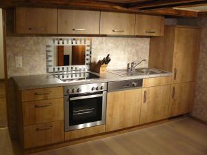 a kitchen with a stove and a sink at Apartment Lindi in Lütschental