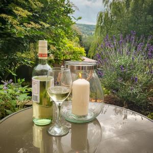 a candle and two glasses of wine on a table at Castleside House in Matlock
