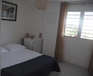 ル・ムルにあるLes jardins d'Émilieのベッドと窓のある寝室