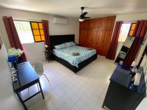 a bedroom with a bed and two tables and windows at Casa Corona Plaza in Santiago de los Caballeros