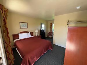 a hotel room with a bed with a red bedspread at Relax Inn in Natural Bridge in Natural Bridge