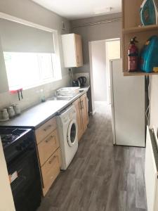 a kitchen with a washer and a white refrigerator at Air Host in Walsall