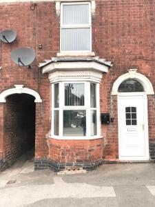 a brick building with a white door and a window at Air Host in Walsall