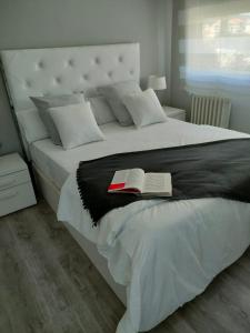 Un dormitorio con una cama con un libro. en Claro de Luna, en Pontevedra