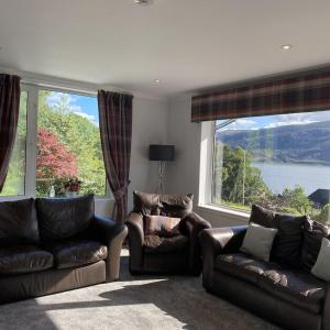 a living room with two couches and a large window at Foinaven House in Ullapool