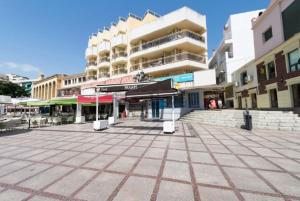 a city square with a building and tables and chairs at Puerta del Sol TRM only adults Aparts in Torremolinos