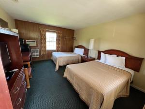 a hotel room with two beds and a television at Relax Inn in Natural Bridge in Natural Bridge
