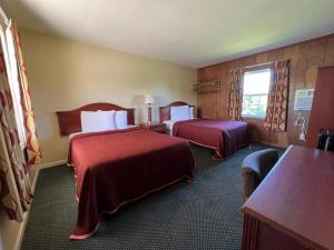 Habitación de hotel con 2 camas y mesa en Relax Inn in Natural Bridge, en Natural Bridge
