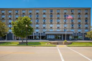 un edificio con una bandera americana delante de él en Best Western Riverfront Inn, en Marinette