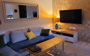 sala de estar con sofá azul y TV en Comfort Warszawa, en Varsovia