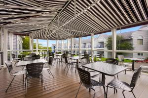 an outdoor patio with tables and chairs and windows at Best Western Harbour Pointe Lakefront in Saint Ignace