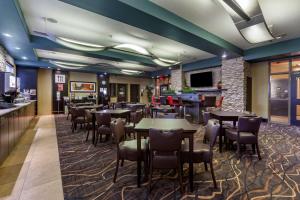 um restaurante com mesas e cadeiras e um bar em Best Western Plus The Inn at St Albert em St. Albert